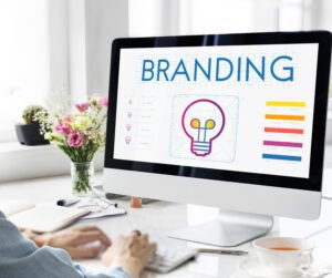 Computer screen displaying the word 'branding' with a lightbulb illustration, highlighting franchise brand development.