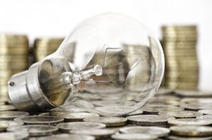 Franchise funding options: Lightbulb on a pile of coins symbolizing financial strategies for business expansion.