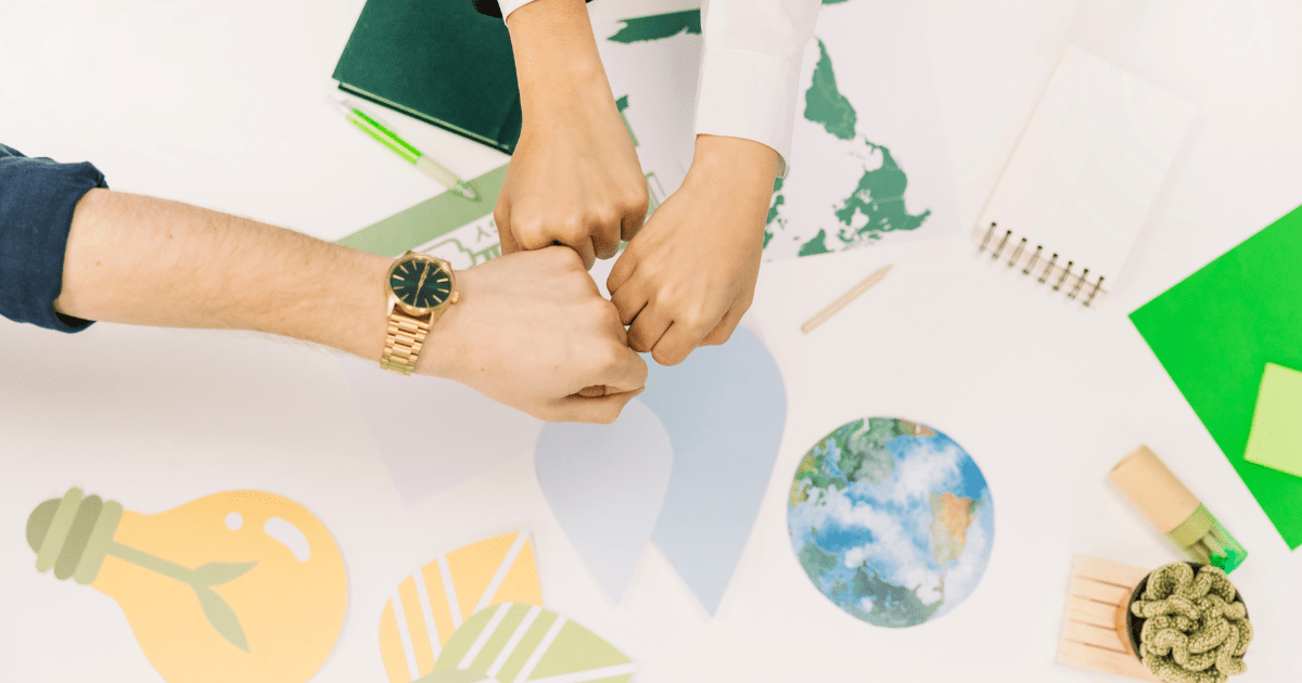 Business Partners Fist-Bumping Over Global Expansion Planning Materials With World Map