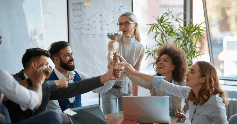 Business team celebrating a performance award, demonstrating how recognition-based franchise incentives boost team morale and motivation.