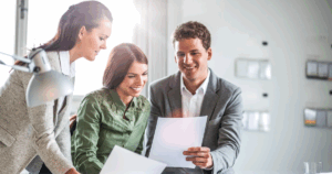 Mortgage professionals reviewing documents in a collaborative office, representing the Co/LAB Lending Franchise support system.