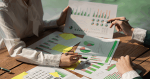 Business professionals reviewing charts and financial reports during franchise business plan development.