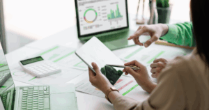 usiness professionals reviewing market data on tablet and laptop while adapting franchise plans for growth.