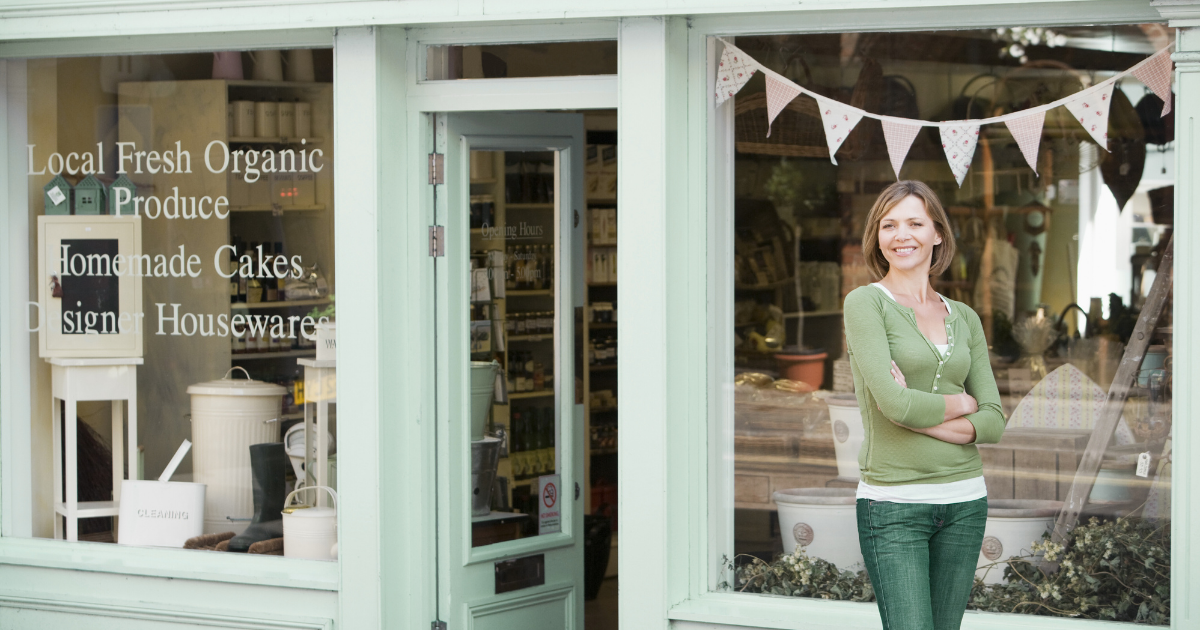 Small business owner outside storefront considering growth options and learning how to choose a franchise wisely