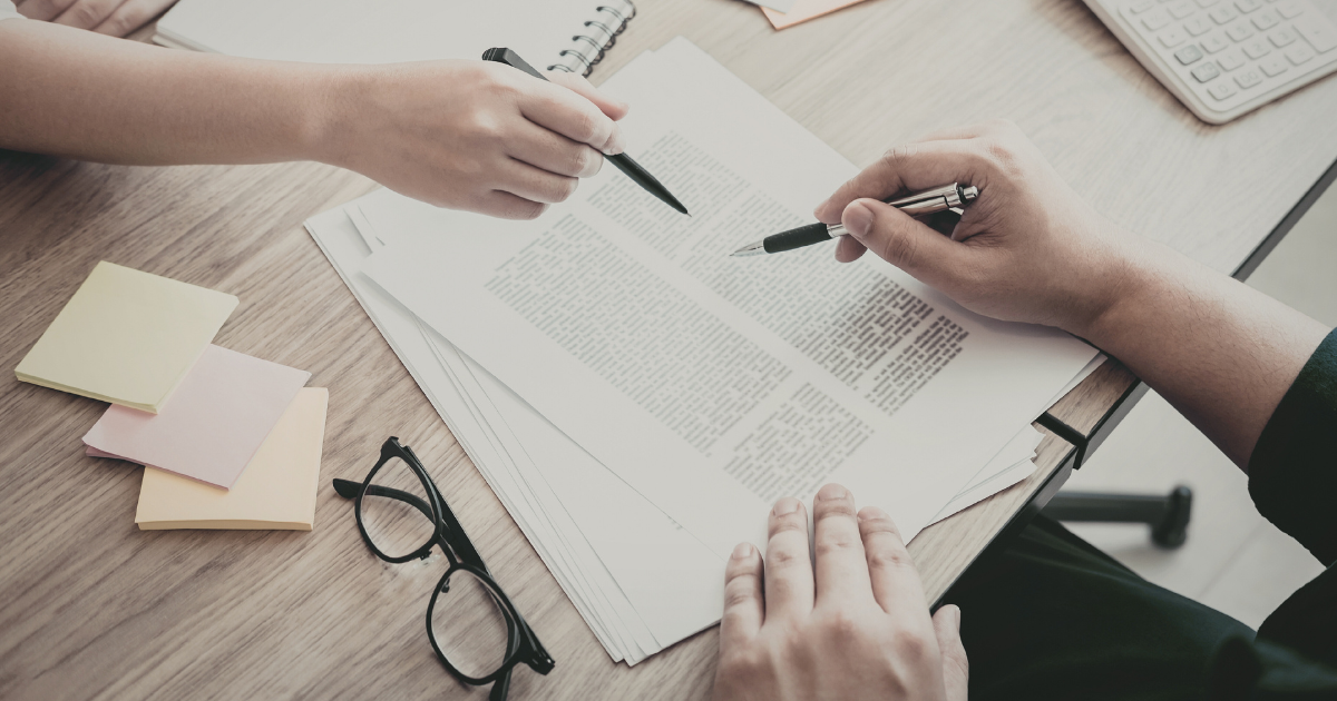 Business owners reviewing legal documents while addressing trademark conflicts when franchising and planning brand expansion